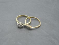 A diamond solitaire dress ring, approx 0.128ct and a three stone diamond trilogy ring, both on