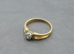 A diamond solitaire dress ring, approx 0.065ct in an illusionary mount to moulded shoulders on a