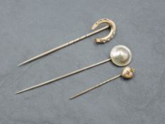 A yellow metal tie pin with horse shoe form terminal, 7cm, sold along with a yellow metal tie pin