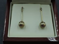 A pair of 9ct gold stud earrings having facetted diamond cut spheres on bar drops, approx 2.4g
