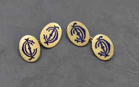 A pair of yellow metal cufflinks stamped 18ct, of oval form bearing blue enamel monograms, with
