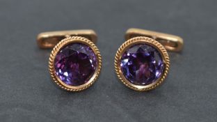 A pair of yellow metal cufflinks stamped 14A having facet cut heat treated amethyst stones and bar