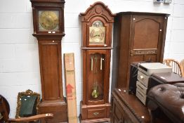 A reproduction long case clock having stained frame case, and brass face