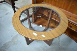 A vintage circular teak laminate coffee table having glass top