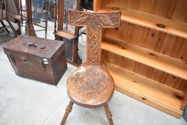 An Arts and Crafts oak spinning chair having extensive carved decoration