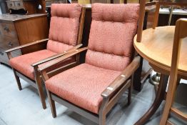 A pair of vintage teak framed easy chairs (Parker Knoll or similar) having upholstered seats and