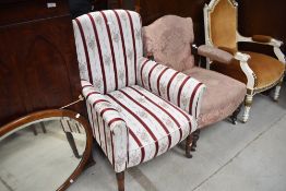 A Victorian easy chair having mahogany turned legs, with later striped upholstery