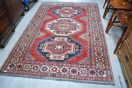 A North West Persian rug with three large central guls enclosed by multiple borders 210cm x140cm
