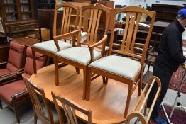 A vintage part teak extending dining table and seven (six plus one) dining chairs