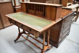 A reproduction Regency style desk having stationery rack top on turned frame