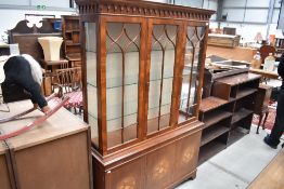 An early 20th Century yew wood bookcase having inlay effect cupboard base