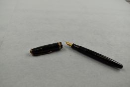 A Parker Duofold fountain pen in black with broad decorative band to cap having Parker N nib. Approx
