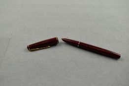 A Parker 17 lady fountain pen in burgundy with narrow band to the cap. Approx 11.7cm