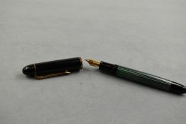 A Pelikan 120 piston fill fountain pen in green striated pattern and black cap having Parker Duofold