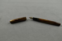 A Waterman Stalwart leverfill fountain pen in gold and brown with two narrow bands to the cap having