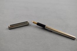 A Dunhill cartridge/ converter fountain pen in silver with engine turned decal having Dunhill 14k