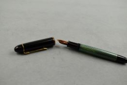 A Pelikan 140 piston fill fountain pen in green striated pattern and black cap having Pelikan 14ct