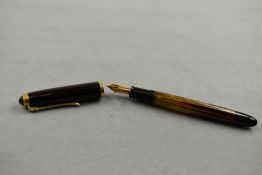 A Pelikan 400 piston fill fountain pen in gold/brown striated pattern and black cap having Pelikan