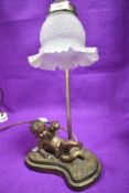A figural lamp base having decorative cherub