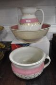 A wash jug and bowl set having white ground with pink and gilt decoration