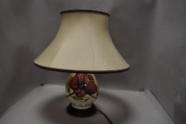 A modern Moorcroft table lamp in the hibiscus pattern with cream ground
