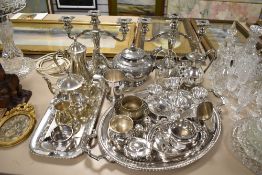 A large collection of silver plated table wares including tea set, candle sticks and serving trays