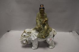 A Chinese style figure of a Tibetan monk sat on elephant