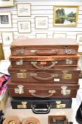 A selection of graduated leather suit cases and attache case