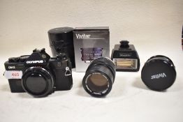 An Olympus OM-2 body with Olympus OM- System E Zuiko Auto 135mm 3,5 lens, a Vivitar 19mm 3,8 wide