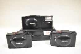 Three Olympus XA cameras one cased