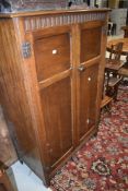 An Edwardian hall way oak cased cupboard or wardrobe