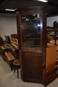 An early 20th Century mahogany corner display with lower cupboard section