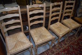 A set of four traditional ladder back rush seated dining chairs