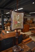 A 19th Century mahogany pole screen having woolwork inset