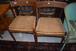 A pair of mid century Danish design teak chairs having woven fibre seats