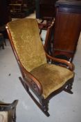 A Victorian mahogany frame rocking chair with mustard upholstery