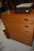A vintage teak laminate on chipboard chest of six long drawers, having brass campaign handles