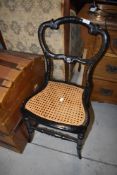 A Victorian laquered bedroom chair having mother of pearl inlay decoration