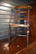 A 19th Century stained frame rocking chair having rush seat, some historical worm evident