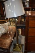 A traditional brass standard lamp, with modern shade