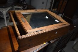 An early 20th Century oak bathroom cabinet, having mirrored door and towel rail, with label for