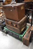 An assortment of vintage luggage, including some with shipping labels