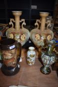 A pair of early 20th century urns having floral decoration and handles to sides, also included are