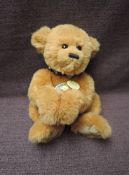 A Charlie Bears Jointed Teddy bear named Riley having plastic eyes, stitched nose and mouth, brown