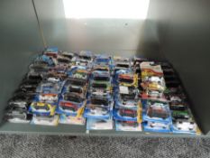 A shelf of 21st century Mattel Hotwheels diecasts, all in blister packs, approx 95