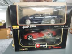 Two Maisto 1:18 scale diecasts, Special Edition Jaguar XJ220 and Dodge Viper, both in window display