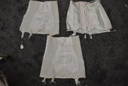 Three vintage girdles, two having zip fastenings and one with hook and eye.