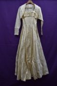 A full skirted 1950s cream brocade wedding dress and bolero.