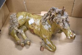 A studio pottery figure of a unicorn signed MH having naturalistic glaze