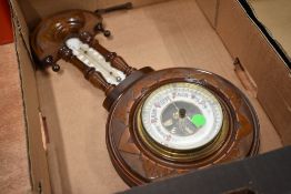An Edwardian stipple carved barometer with enamelled dial and thermometer scale